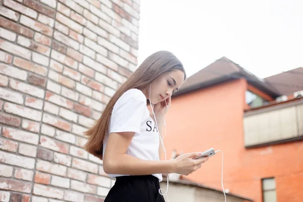 Mujer joven con auriculares colgando en su teléfono móvil — Foto de Stock
