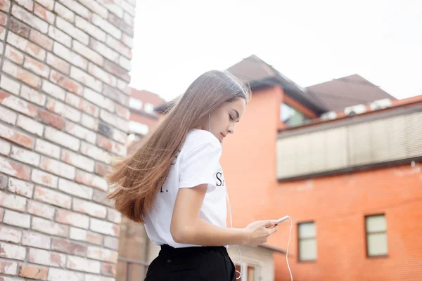 Mujer joven con auriculares colgando en su teléfono móvil — Foto de Stock