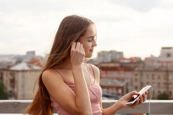 젊은 여 자가 그녀의 휴대 전화에 매달려 헤드폰 — 스톡 사진