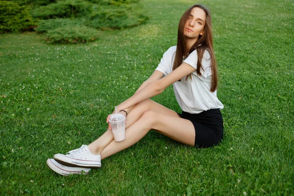 Porträtt av en ung brunett kvinna i en vit T-shirt — Stockfoto