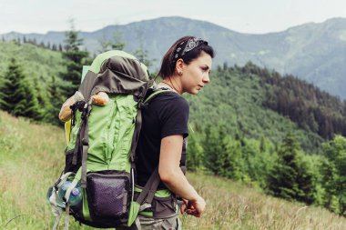 Günbatımı dağ tepe üzerinde zevk sırt çantası ile yenilikçi genç kız