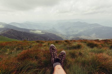 Erkekler bacaklar dağ deniz scape arka planında yatan kahverengi Ayakkabı