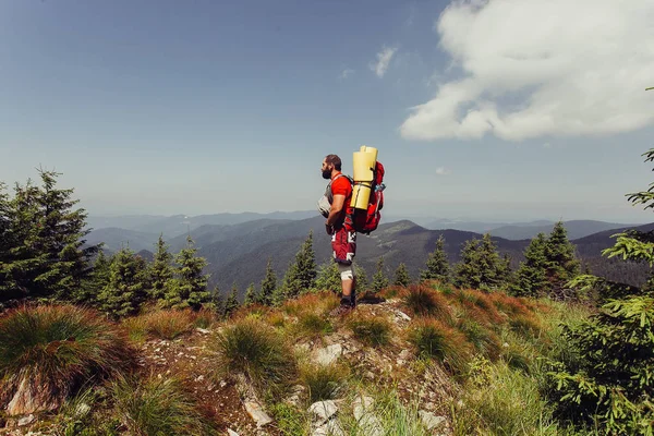 Joven de pie en la cima del acantilado en las montañas de verano — Foto de Stock