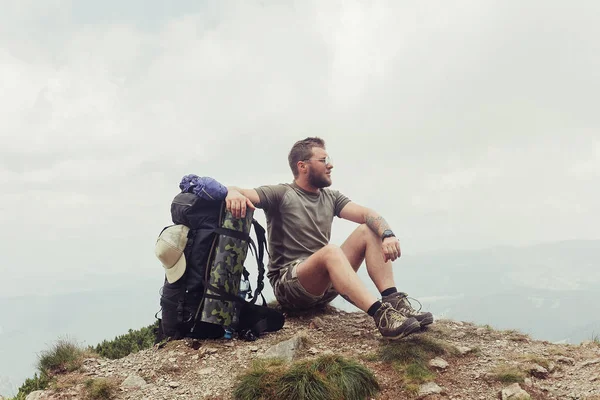 Joven de pie en la cima del acantilado en las montañas de verano — Foto de Stock