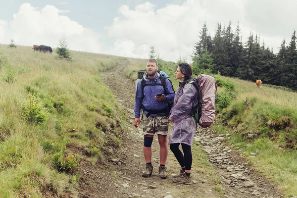 Grupo de excursionistas con mochilas caminan por un sendero hacia una cresta de montaña — Foto de Stock