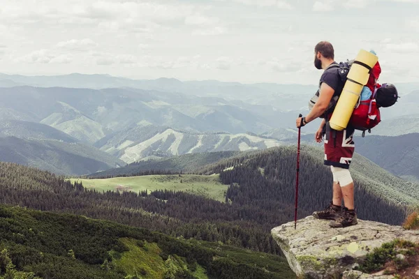 Joven de pie en la cima del acantilado en las montañas de verano — Foto de Stock