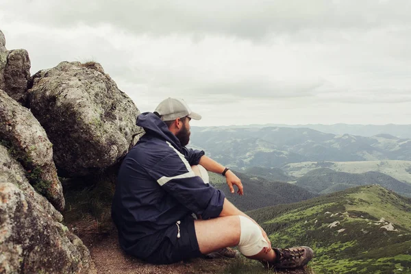 Joven de pie en la cima del acantilado en las montañas de verano — Foto de Stock