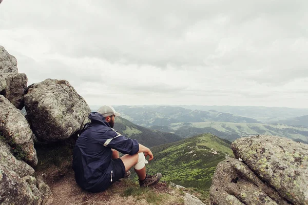 Joven de pie en la cima del acantilado en las montañas de verano — Foto de Stock