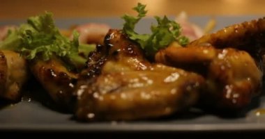Bir taş Dostochka baharat ile serpilir sıcak grillchicken kanatlarında Barbekü biftek pişirme. Ağır çekim