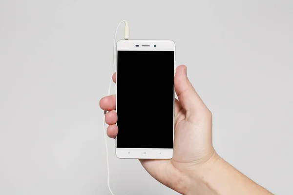 Hand hold phone black screen on wood table — Stock Photo, Image