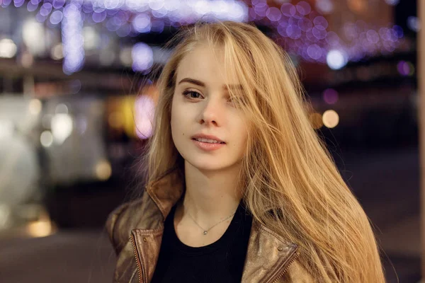 Femme souriant dans la nuit contre les lumières du soir bokeh — Photo