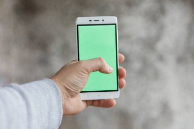 Holding ve telefon ile yeşil perde Dikey dokunmadan Closeup adam el