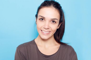 Mavi arka plan üzerinde gülümseyen güzel kadın.