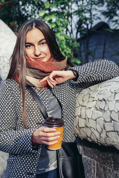 Lady with a cup of coffee walking down the city street — стоковое фото