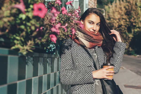 Lady with a cup of coffee walking down the city street — стоковое фото