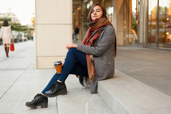 Lady with a cup of coffee walking down the city street — стоковое фото