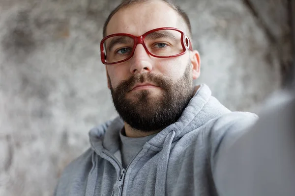 Homem no estúdio vestindo óculos nerd vermelho rindo — Fotografia de Stock