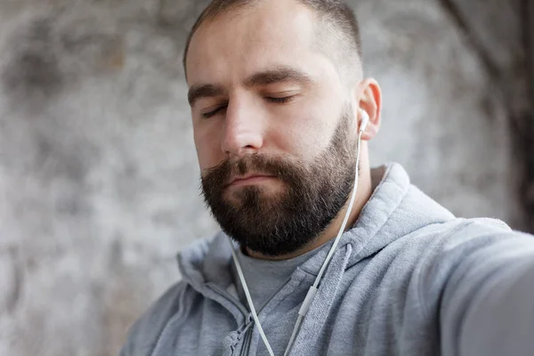 man in studio puts ear phones out to music.