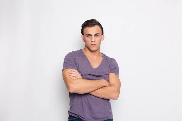 Handsome young man on grey background looking at camera — Stock Photo, Image