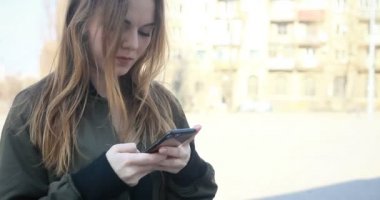 teknolojileri, duygular, yaşam, güzellik, insanlar, 4 k kavramı - cep telefonuyla yazarak. Kız, manifatura mesaj. Holding ve seyir akıllı telefon oldukça gülümseyen genç kadın
