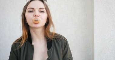 gülümseyen ve kamera seyir insanlar, sağlık, 4 k, diş hekimi ve yaşam tarzı kavramı - açık şık kıyafet sakız, genç çekici kadın portresi. Ciklet Şişirme hippi kız portresi