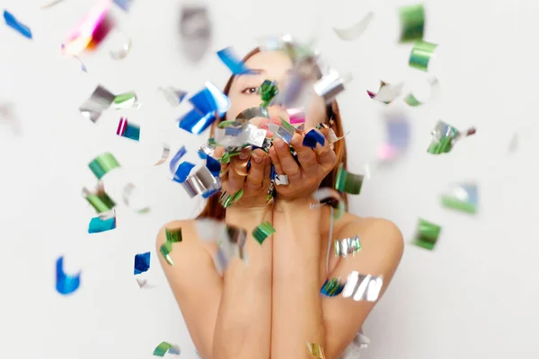 Morena mujer con el pelo largo sonriendo y confeti cae por todas partes . — Foto de Stock