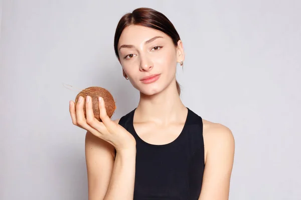 Chica con un maquillaje natural ligero con coco en la mano — Foto de Stock