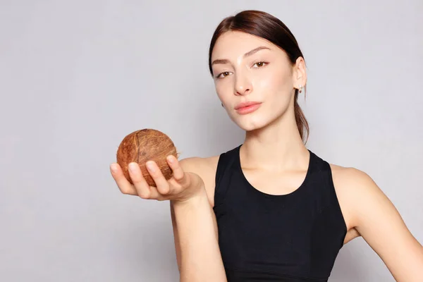 Chica con un maquillaje natural ligero con coco en la mano — Foto de Stock