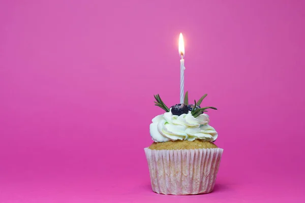 Birthday cupcake with one burning candles over pink background — Stock Photo, Image