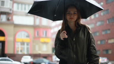 sezon, hava durumu ve insanlar kavramı - genç esmer kadın şemsiye ile sokakta onun elinde yağmurlu günde durumda