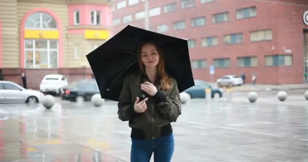 の概念 若いブルネットの女性傘の通りに彼女の手の上に立つ雨の日 — ストック動画