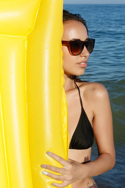 Žena, plavání s nafukovací prstenec na pláži v létě slunečný den — Stock fotografie