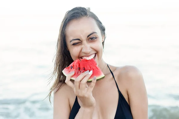 Vacaciones de verano - niña comiendo sandía fresca en la playa de arena — Foto de Stock
