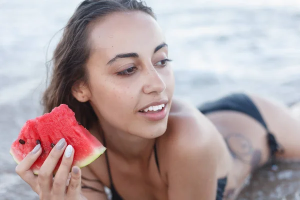 Nyaralás - fiatal lány eszik friss görögdinnye, homokos strandon — Stock Fotó