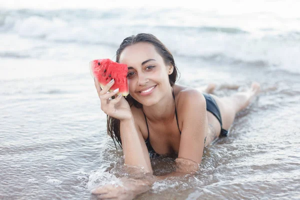 Letní dovolená - mladá dívka jíst čerstvé meloun na písečné pláži — Stock fotografie