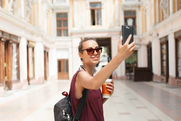 Selfies を取ってスマート フォンを保持している美しい若い観光客女性の肖像画 — ストック写真