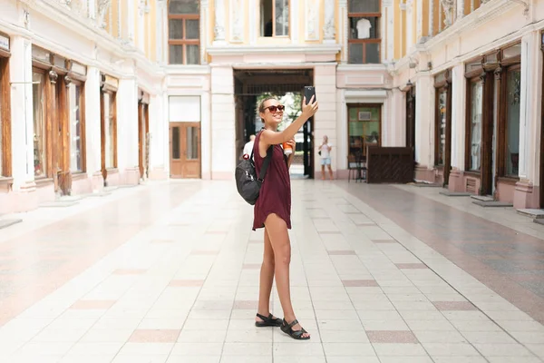 Retrato de bela jovem turista segurando um smartphone tirando selfies — Fotografia de Stock