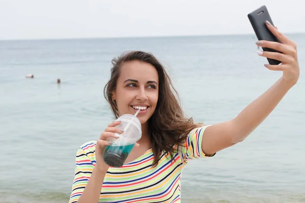 Пляжная женщина, пьющая холодный напиток, развлекаясь на пляжной вечеринке . — стоковое фото