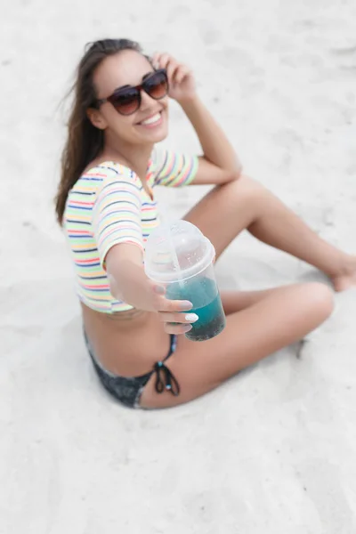 Пляжна жінка п'є холодний напій, розважаючись на пляжній вечірці . — стокове фото
