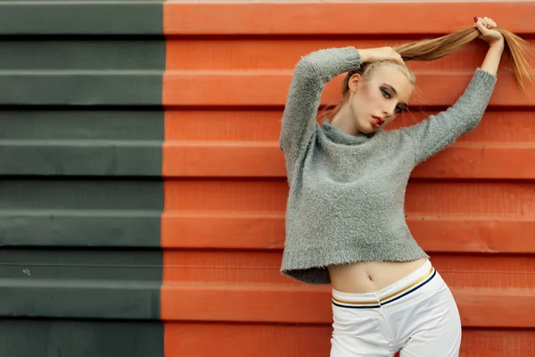 Model pointing upwards in studio and looking at camera