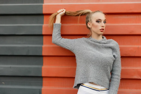 Model pointing upwards in studio and looking at camera