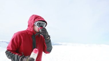 Genç snowboardcu kış kayak merkezinin önünde neşeli bir gülümseme mavi gözler kask spor yaşam tarzı aşırı erkek dağları kayak yapan insanlar. Termostan çay içmek