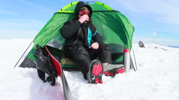 从帐篷露营中 人们悠闲地欣赏云彩群山的空中美景 一个住在山上的雪人坐在帐篷里的画像 从热水瓶里喝茶 — 图库视频影像