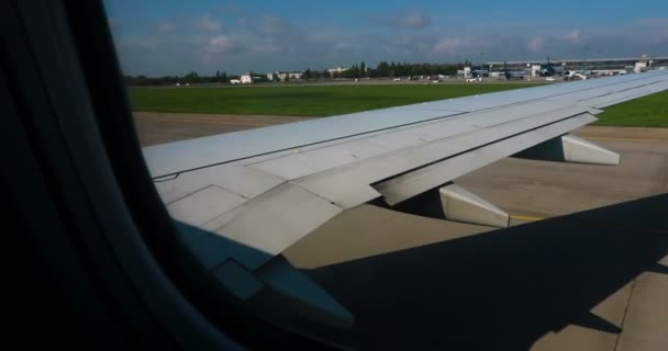 青い空の飛行機の窓からの雲の上の空の景色の素晴らしい映像 飛行機の窓から青い空と白い雲が見えます空から雲を通して地球を見ると — ストック動画