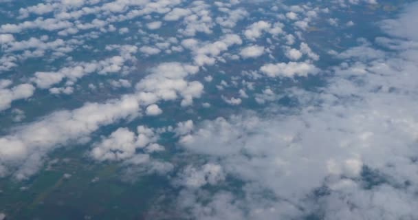 从蓝天的飞机窗上俯瞰云层上方的空中景色 从飞机窗口看到蓝天和白云 透过云彩从天上看地球 — 图库视频影像