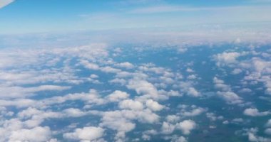 Bulutların üstündeki mavi gökyüzü olan uçak penceresinden çarpıcı görüntüler. Uçak penceresinden mavi gökyüzüne ve beyaz bulutlara. Dünya 'nın gökyüzünden görünüşü bulutların arasından.