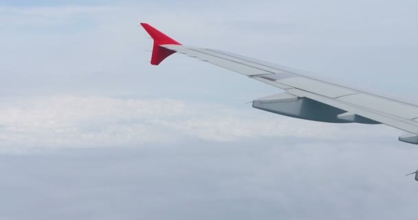 青い空の飛行機の窓からの雲の上の空の景色の素晴らしい映像 飛行機の窓から青い空と白い雲が見えます空から雲を通して地球を見ると — ストック動画