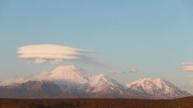 Volkanın günbatımının zamanlaması. Yüksek dağın tepesinde güneş ışığı. Güzel Günbatımı Sahne Dağı 'nın Zaman Filmi. Volkanın üzerinde gün batımı ve gece gökyüzünde yıldızlar. 4k