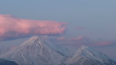 Volkanın günbatımının zamanlaması. Yüksek dağın tepesinde güneş ışığı. Güzel Günbatımı Sahne Dağı 'nın Zaman Filmi. Volkanın üzerinde gün batımı ve gece gökyüzünde yıldızlar. 4k