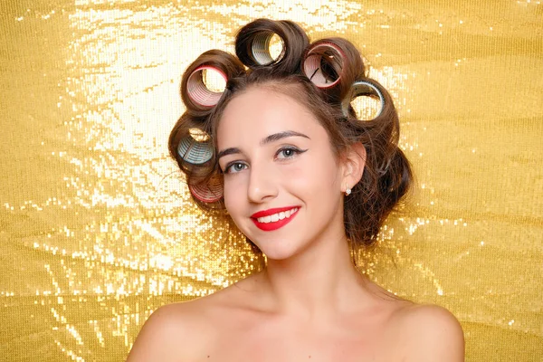 Красивая девушка в бигуди волос изолированы на золото — стоковое фото